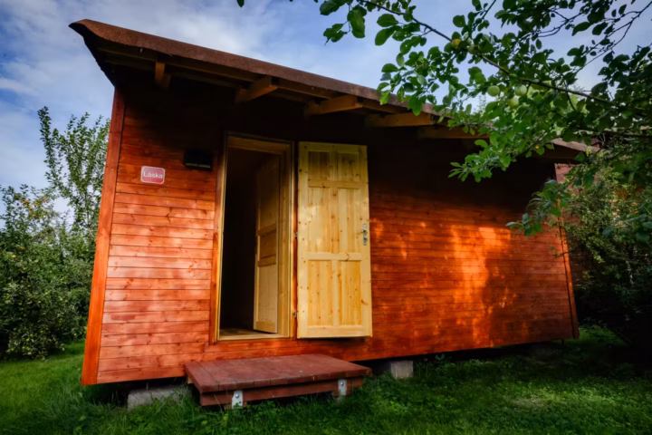 Hütte der Liebe für ein Dunkelretreat unter einem Apfelbaum, Tür offen