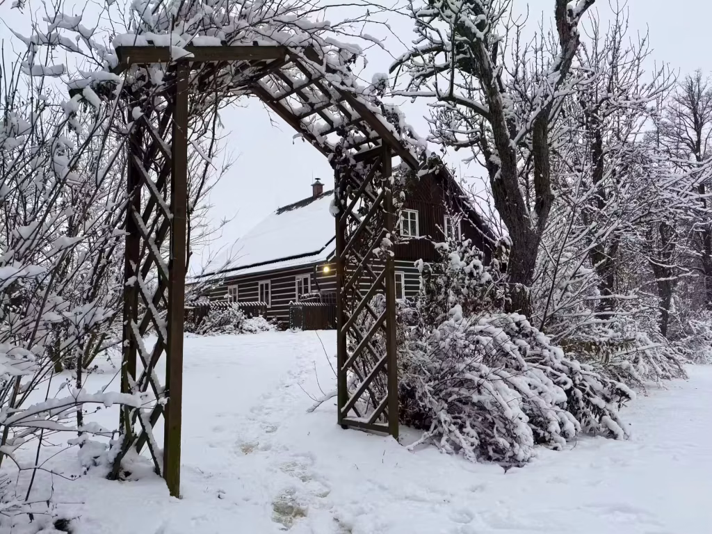 Arco de madera en la nieve junto a las cabañas del retiro de oscuridad